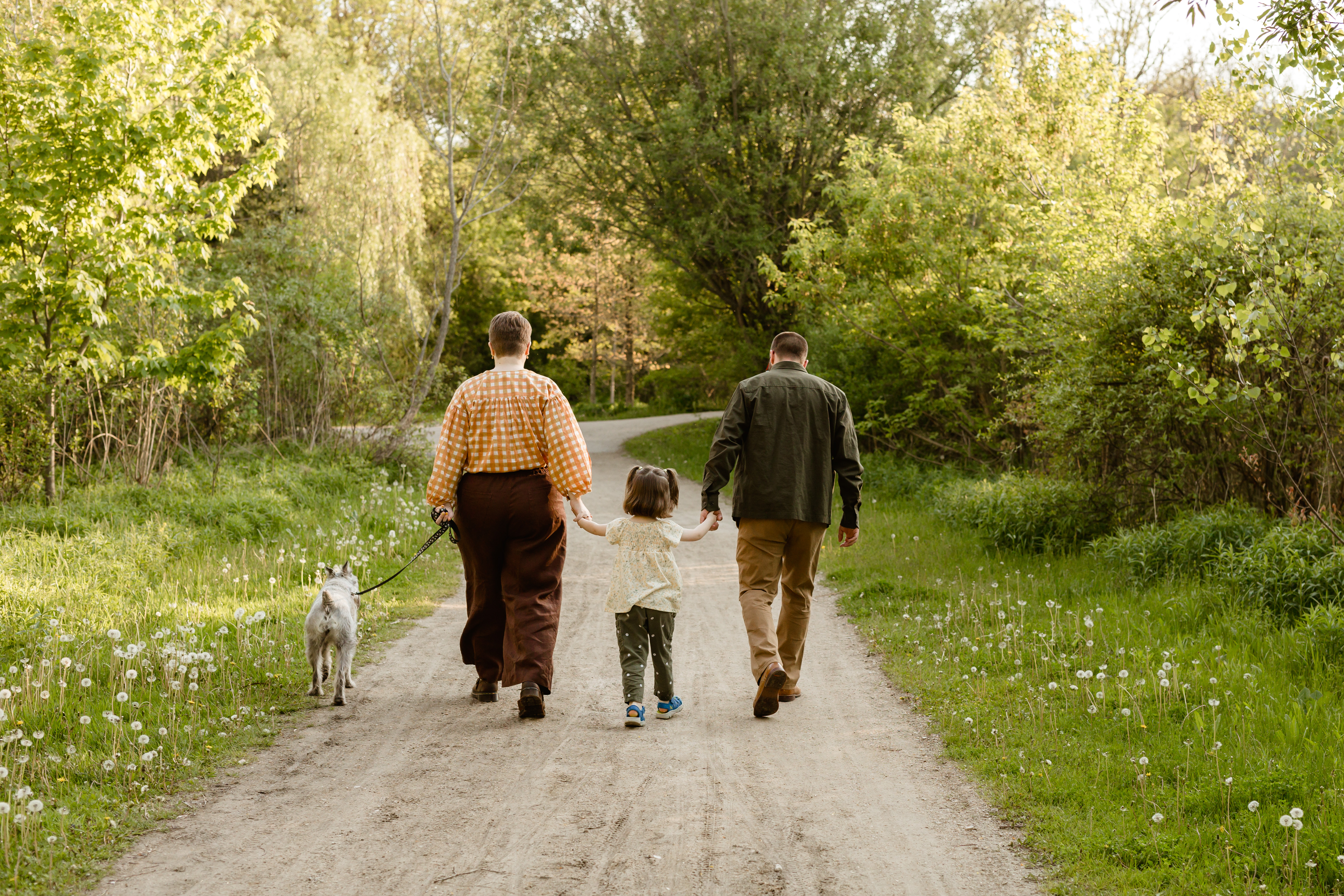 Victoria Richardson holding hands with her daughter and husband walking down a footpath